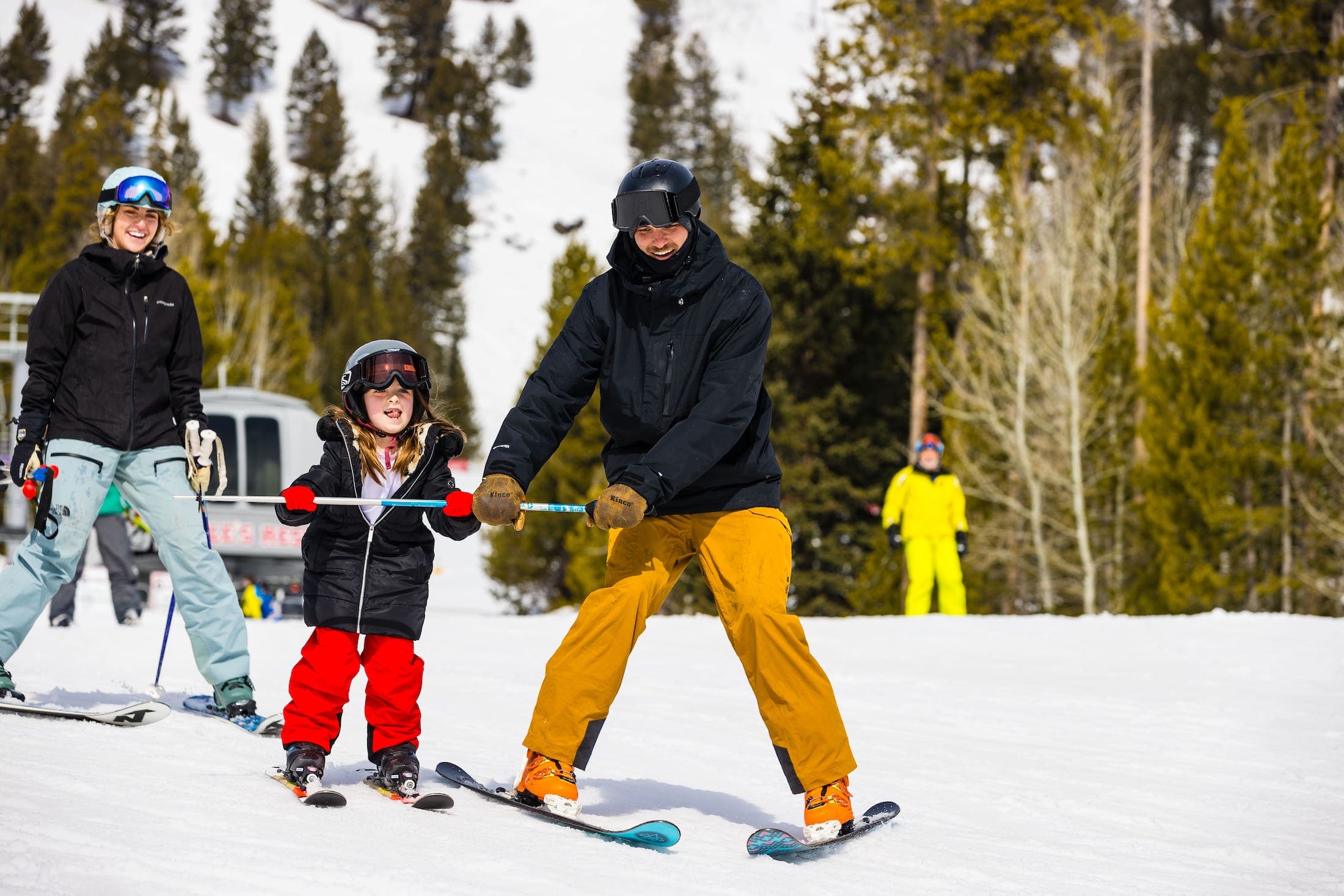 A father helping his daughter downhill ski at Teton Mountain Lodge