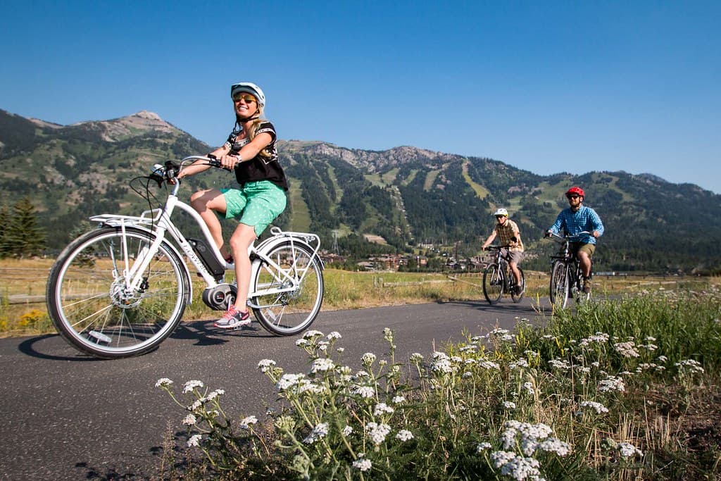 Three people biking on a path in the beautiful mountains of Wyoming