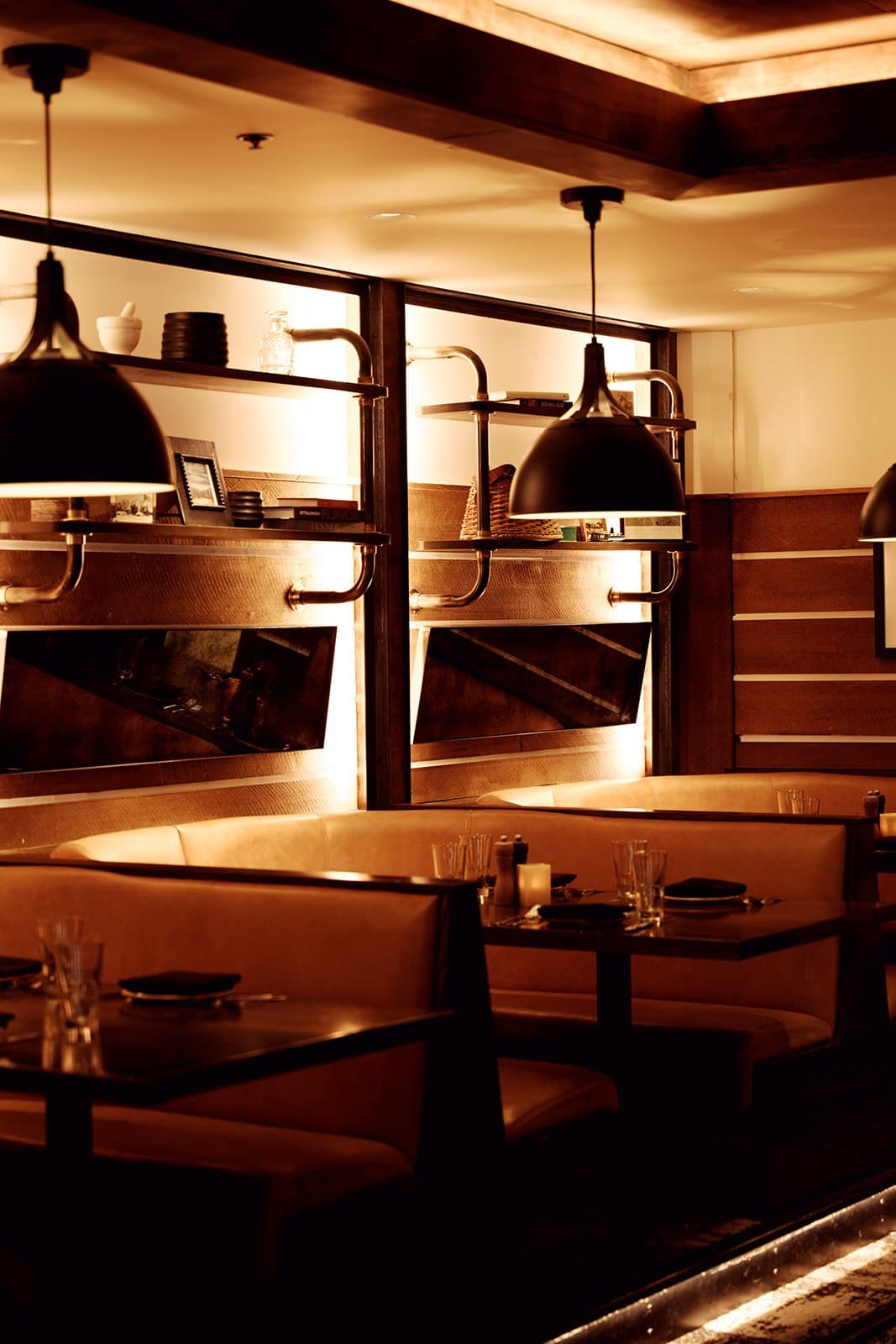 A photo of booth seating in a restaurant with dim, warm lighting