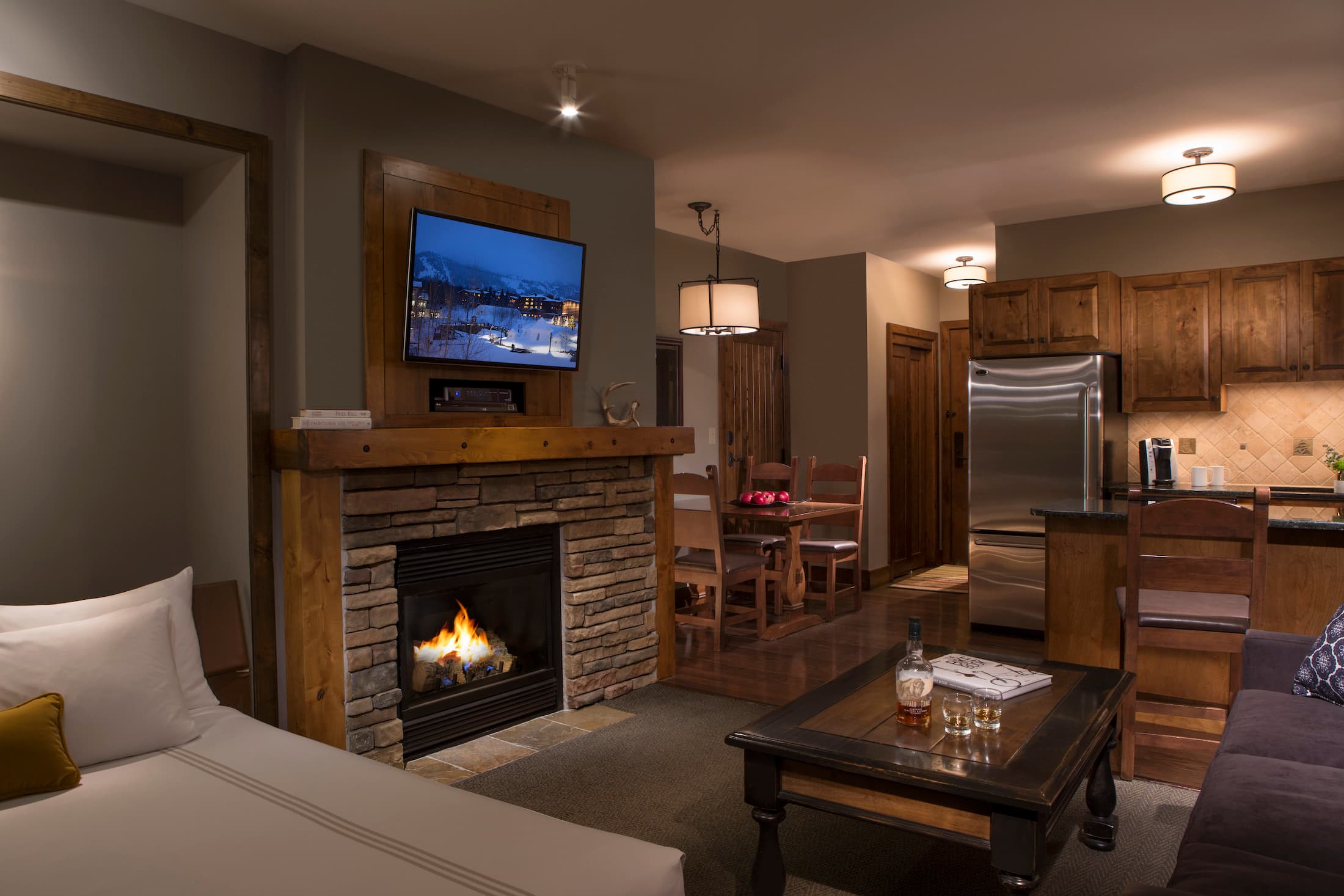 The living space with a fireplace, kitchen, dining area of Teton Mountain Lodge Alpine Studio