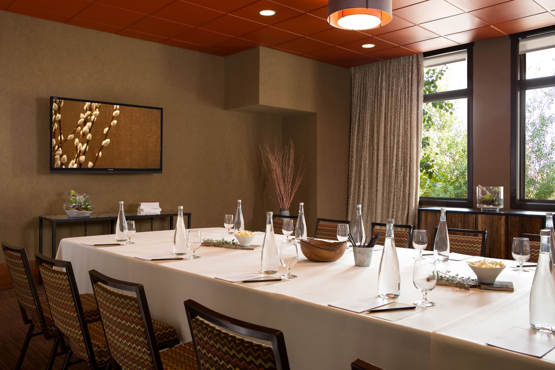 Craighead Room, a long table in a room with a white table cloth with chairs, water glasses and bottles of water