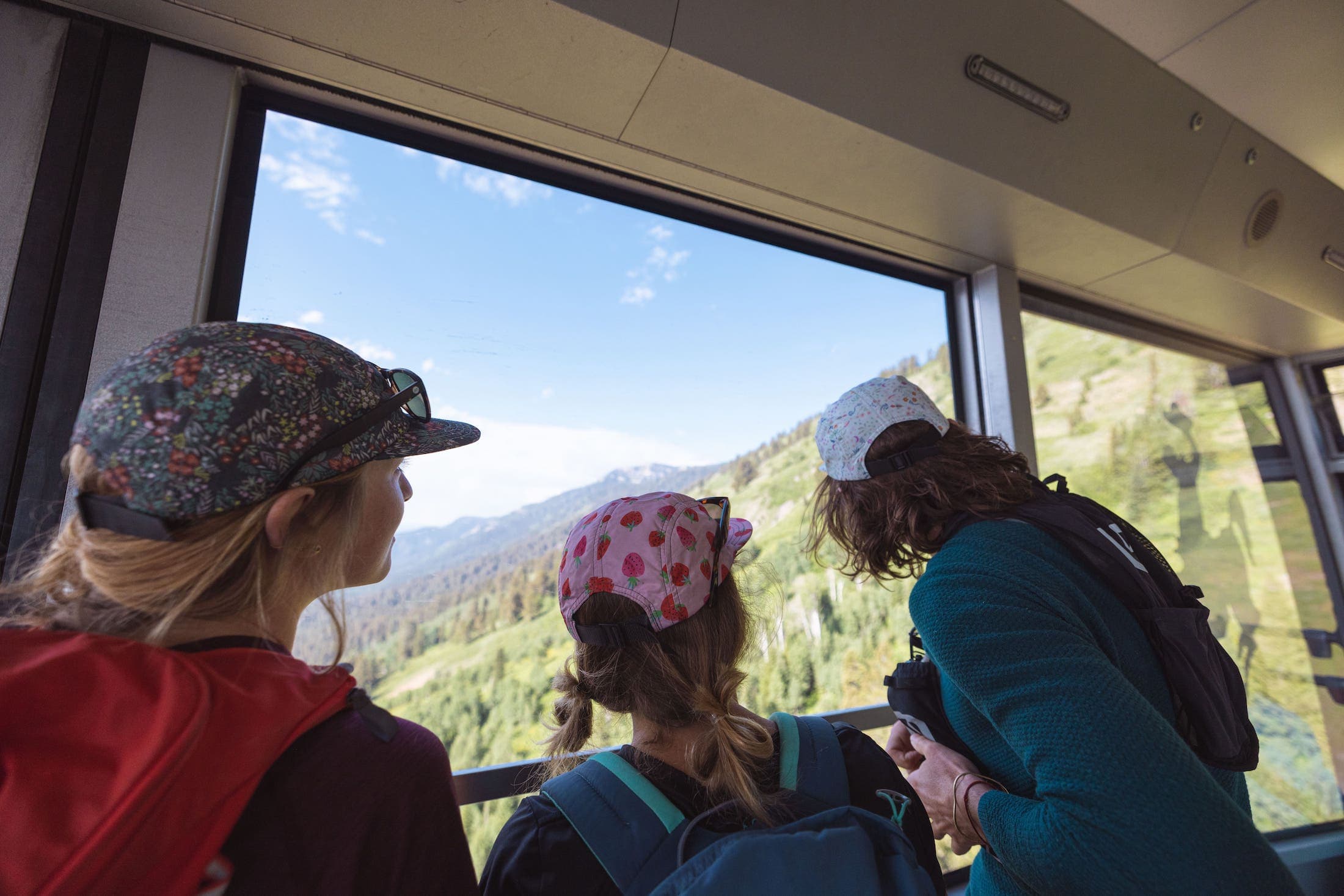 Kids inside of an aerial tram enjoying the scenery