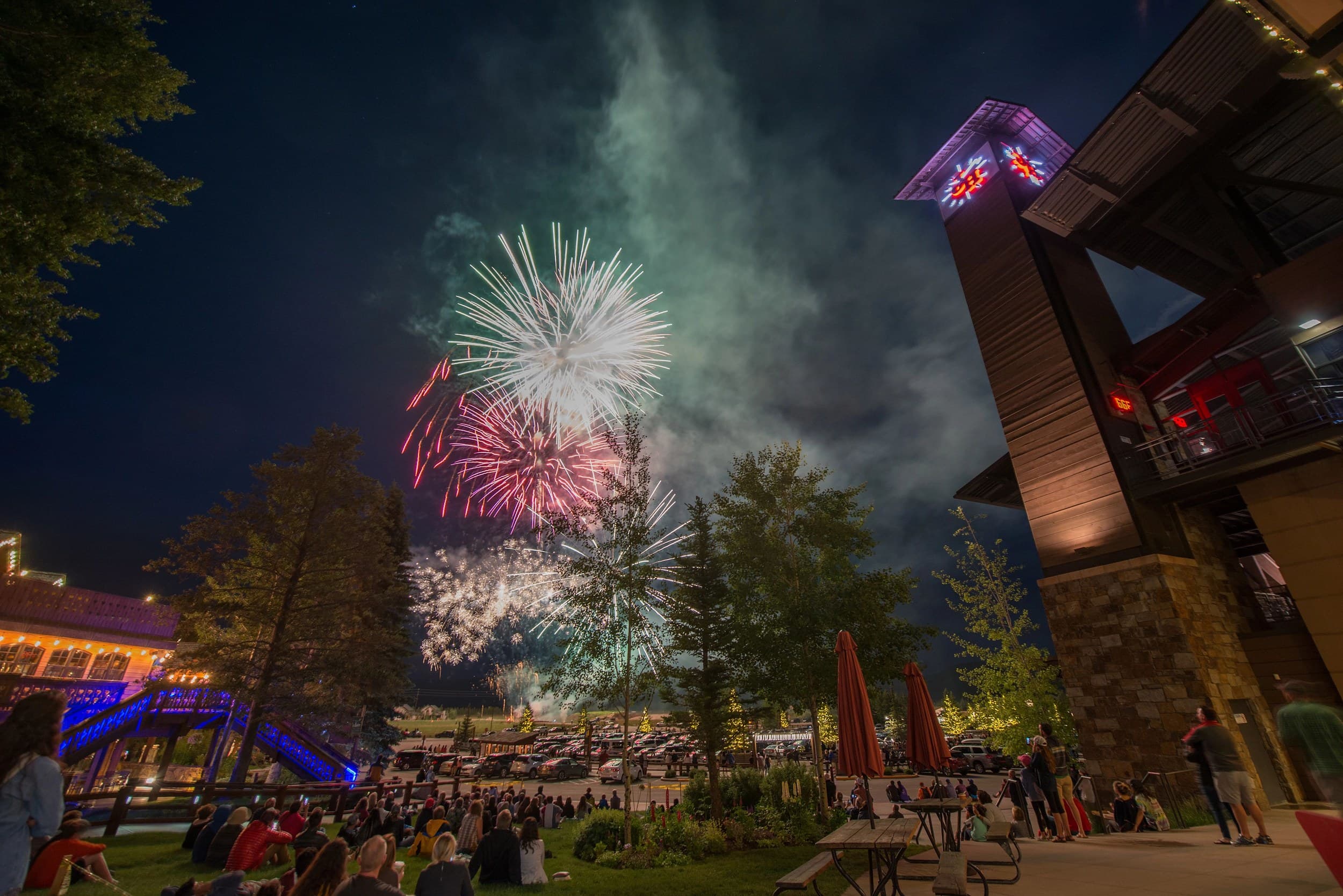Crowd watching a summer fireworks display over the clock tower at Teton Village near Teton Mountain Lodge in Jackson Hole, Wyoming