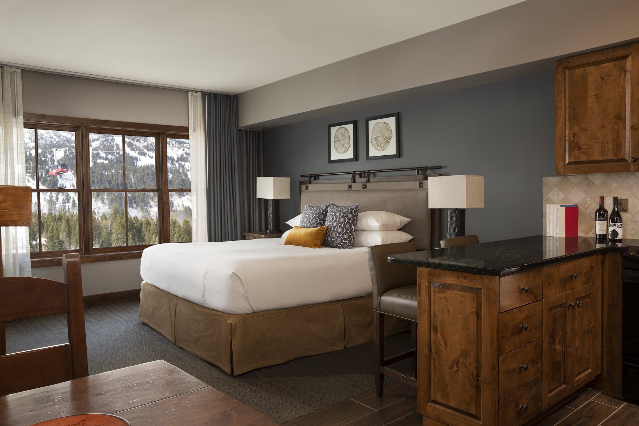 Teton Mountain Lodge Sundance Junior Suite with a large window of the mountains, a kitchen island, and a dining table