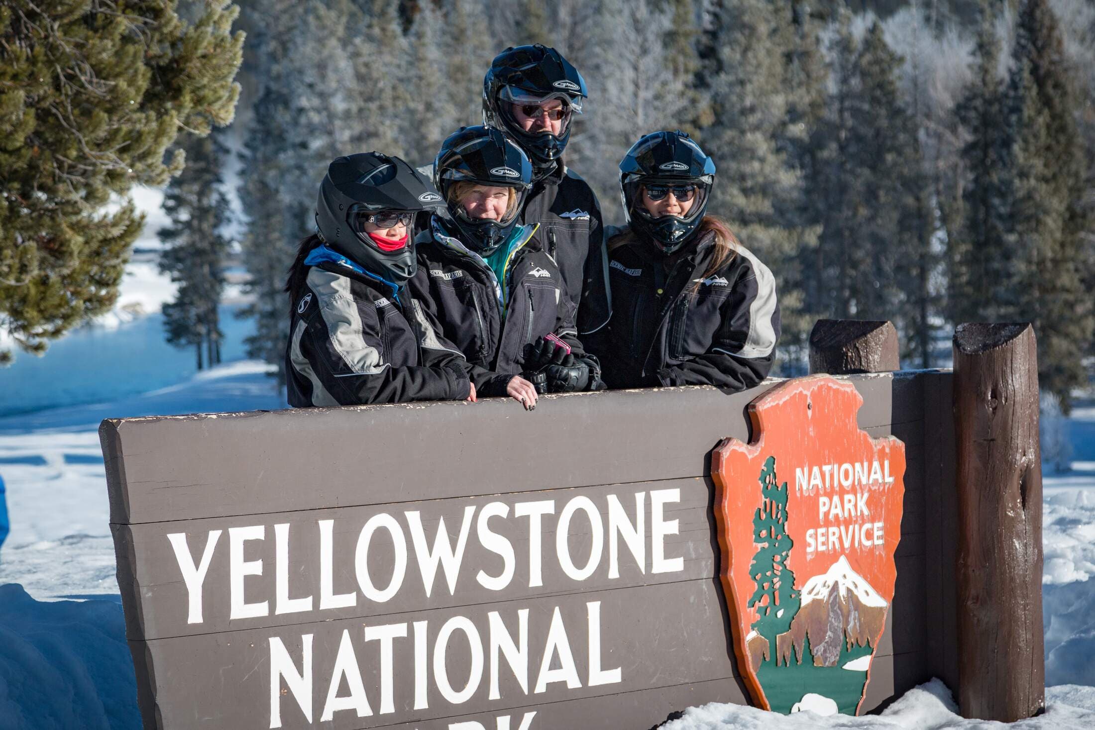 Snowmobile Group at Yellowstone National Park Sign.