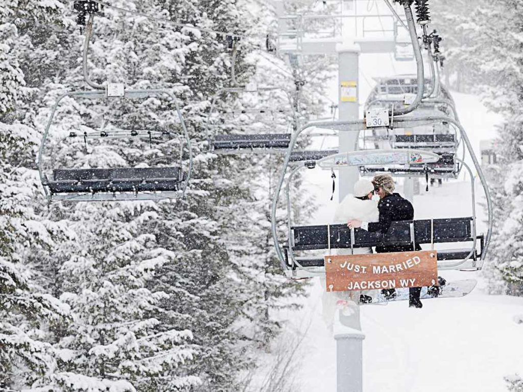 Couple on ski lift with just married sign.