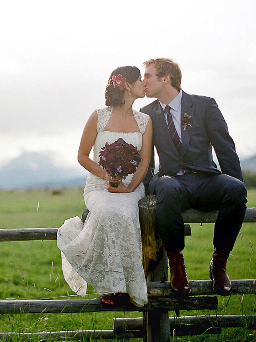 Bride and Groom Kissing On A Fence.